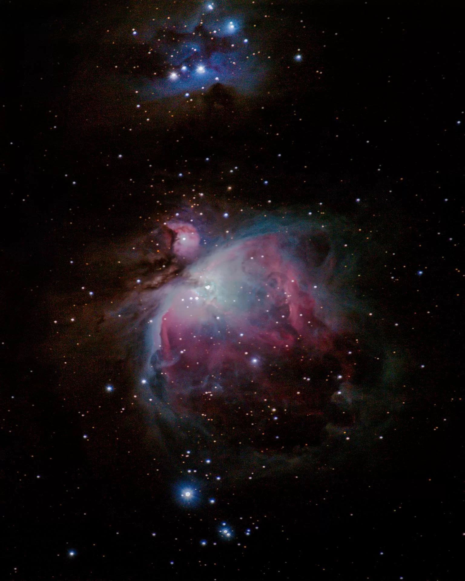 Figure 17 | The Great Orion Nebula (CMC v. 4.0; M42; NGC 1976, bottom); De Mairan's Nebula (M43; NGC 1982, middle); the Running Man Nebula (Sh2-279, top). Photographed on 1/3/2021 from Flanders, NJ, using a Canon EOS RP with a Sigma 150-600mm DG OS HSM f/5-6.3 lens at 600mm, f/13, and ISO 1600 on a Sky-Watcher Star Adventurer 2i Pro tracking at sidereal rate. The rig was used in cropped-sensor mode (with a Kase Neutral Night Light Pollution Clip-In Filter) for a total raw focal length of 960mm. 215x30s images were integrated within DeepSkyStacker for a total of 107 min of data; the output TIFF was then stretched in Adobe Photoshop CC v. 22.1.1 using the Astronomy Tools Action Set (v. 1.6.2 from ProDigital Software) and AstroFlat Pro (v. 1.4.11 from ProDigital Software). A metal print of this image is hanging in Dr. Ciar's office. 